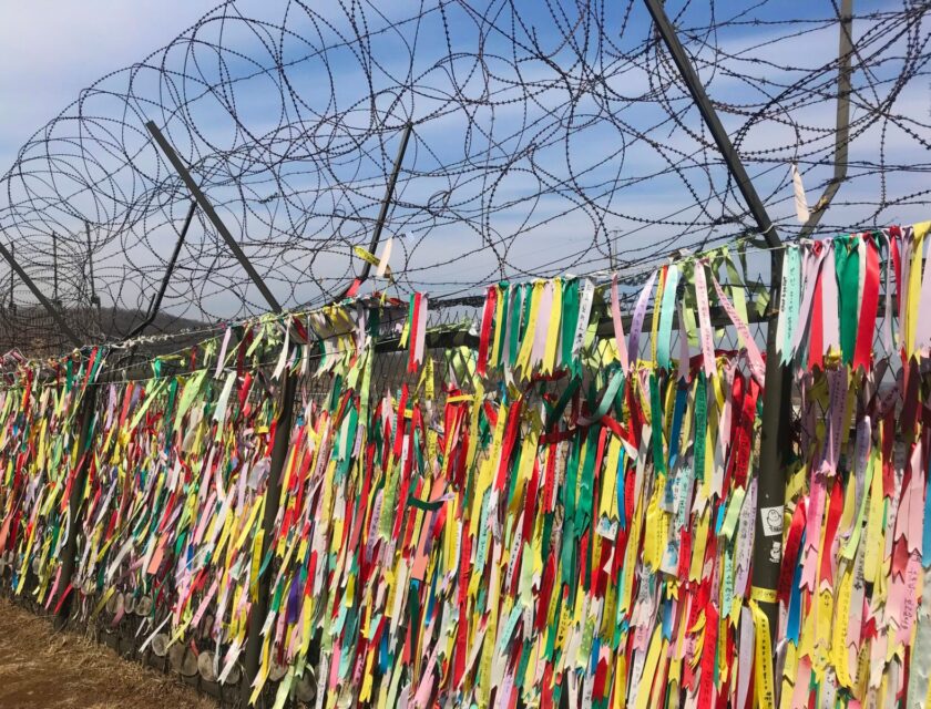 DMZ A Dutchy (iStock) DMZ demilitarized zone North Korea and South Korea - Ribbon memorial on barbed wire fence at border between two countries.