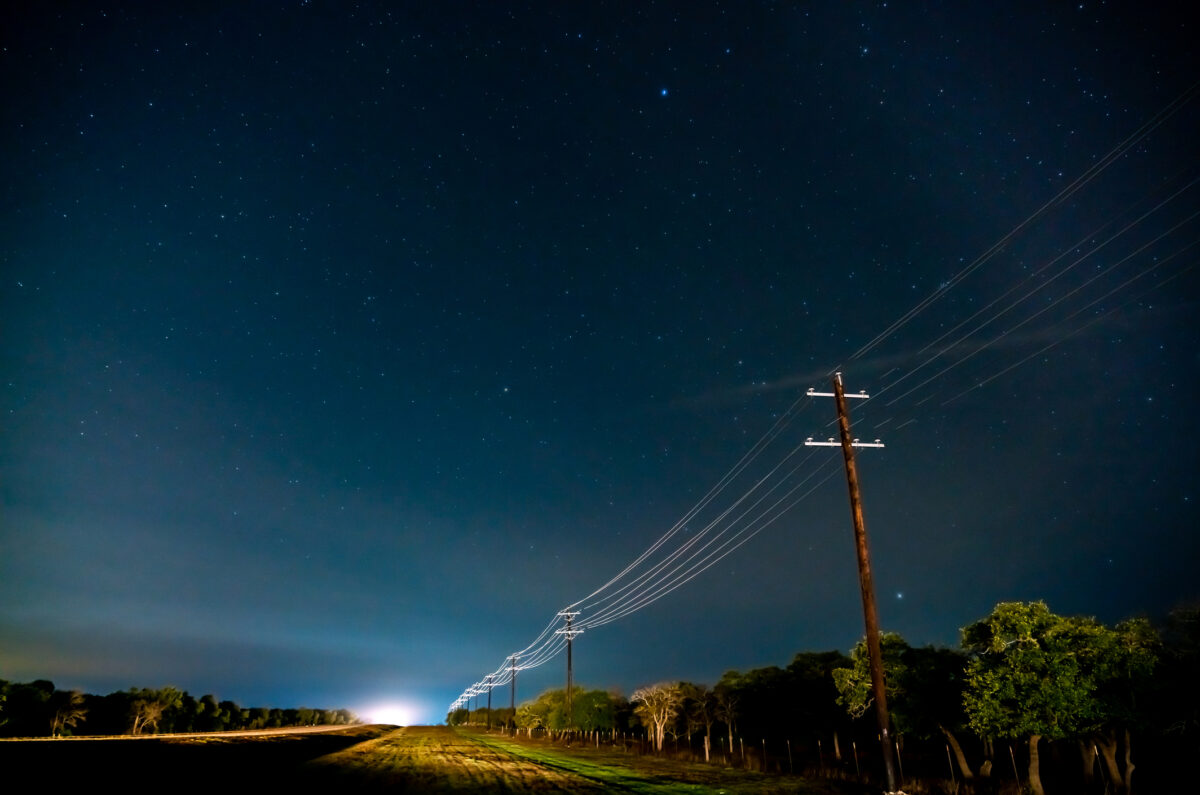 Country Road Illuminated By Traffic in the Night With Stars on Clear Sky
