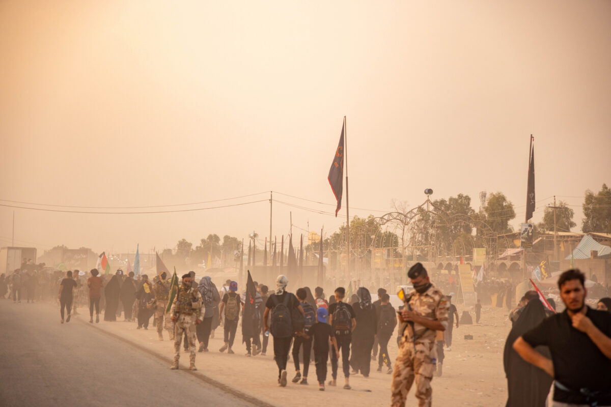 With the discomfort of the first morning approaching and the heat slowly raising, the sand had picked up with the wind and started to attack us. Though if you notice, nobody stopped, people kept going on. An army personal is seen in this image, helping to guide and protect from any threats, this would be along the whole journey and into the city of Karbala itself.